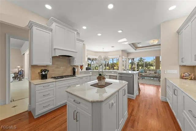 a kitchen with granite countertop a sink a counter top space stainless steel appliances and cabinets