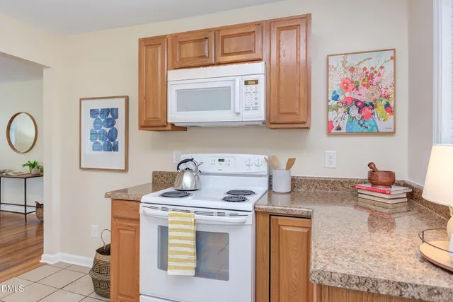 a kitchen with stainless steel appliances granite countertop a stove a sink dishwasher and cabinets with wooden floor