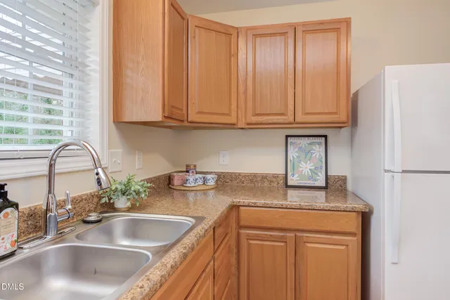 a kitchen with granite countertop a sink and a refrigerator