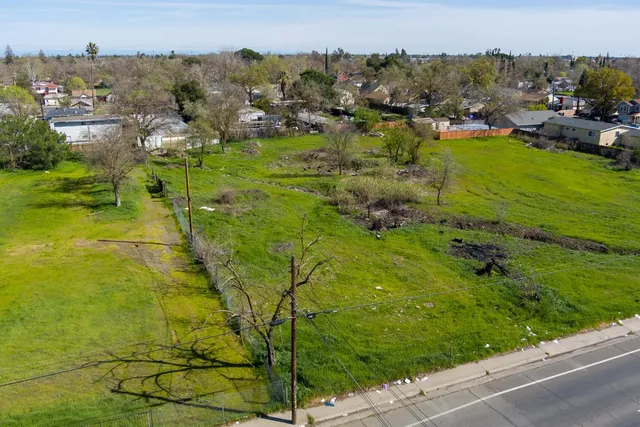 an aerial view of residential houses with outdoor space and trees