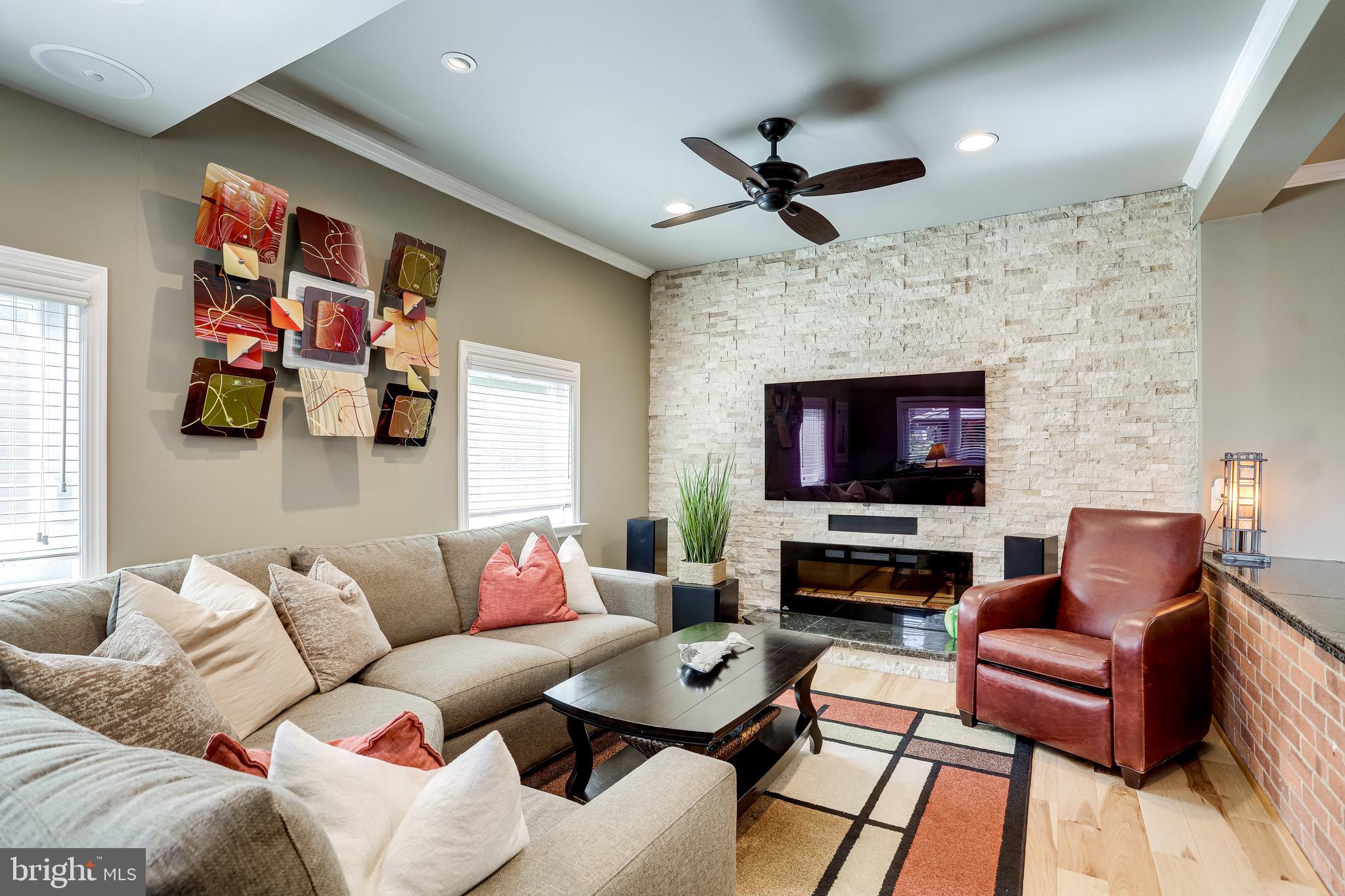 6904 Inverness Drive Springfield, VA 22150 - Photo 13 of 54 Electric Fireplace, Stone Wall, and Ceiling Fan