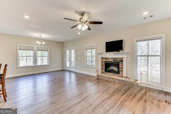 a view of an empty room with window fireplace and wooden floor