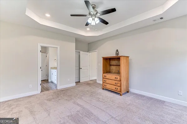 an empty room with closet and a ceiling fan