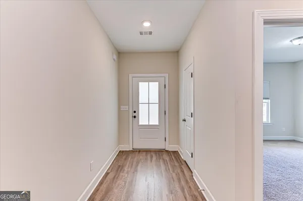 a view of a hallway with wooden floor