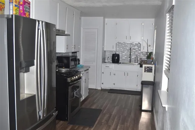 a kitchen with stainless steel appliances a refrigerator sink and cabinets