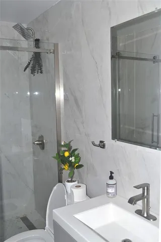 a bathroom with a sink a toilet and shower