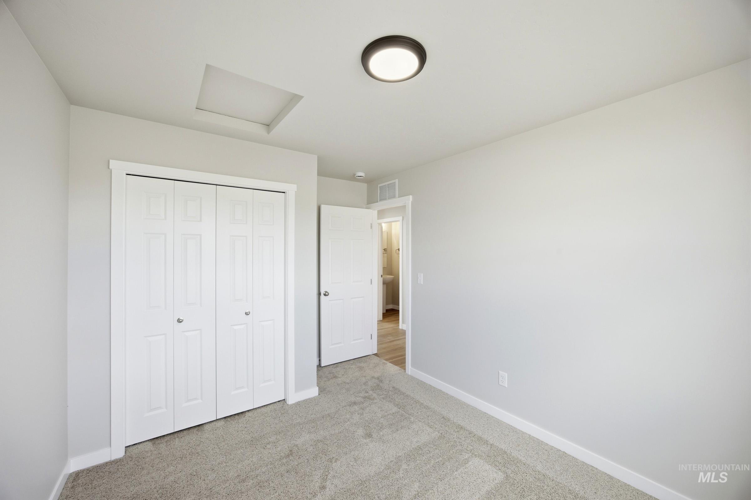 14044 Shiny Spruce Street Caldwell, ID 83607 - Photo 11 of 24 Neutral-toned room featuring a flush-mount ceiling light, light gray carpeting, and white baseboards