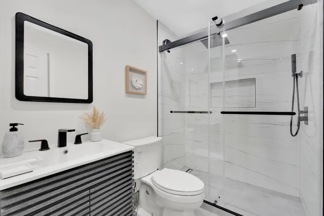 a bathroom with a sink a toilet and shower