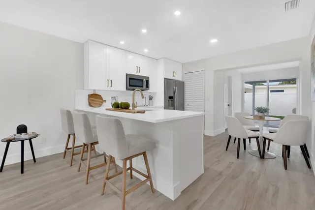 a kitchen with kitchen island white cabinets and stainless steel appliances