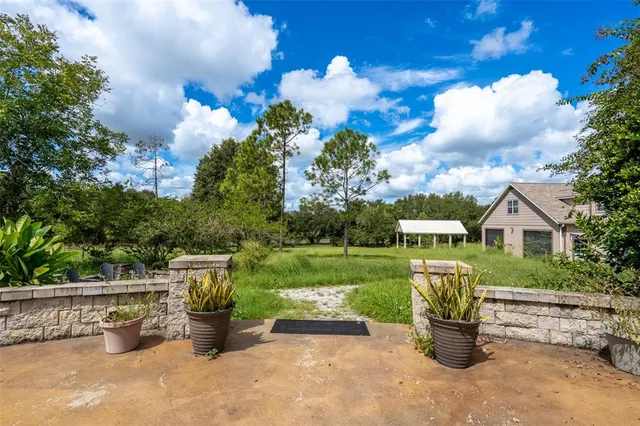 a view of a house with a backyard and sitting area