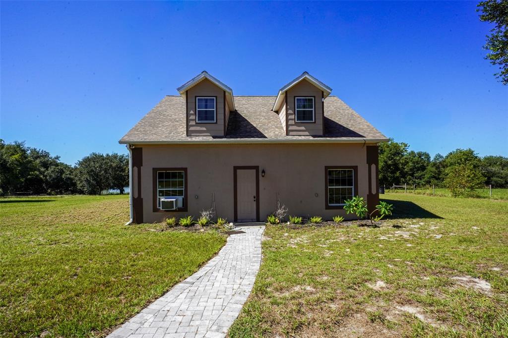 18301 South Obrien Road Groveland, FL 34736 - Photo 22 of 35 a front view of house with yard and trees in the background