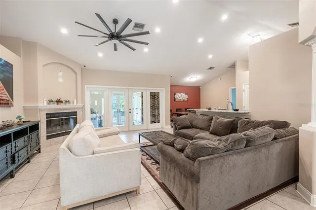 a living room with furniture and a large window with kitchen view