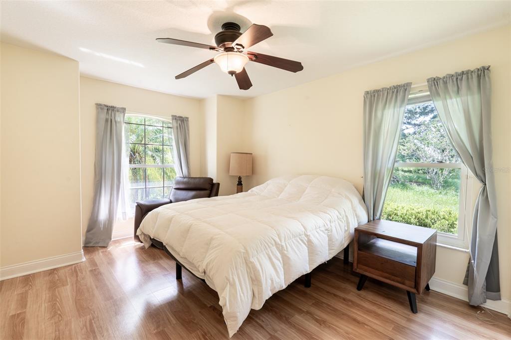 18301 South Obrien Road Groveland, FL 34736 - Photo 7 of 35 a bedroom with a large bed a chandelier and a window