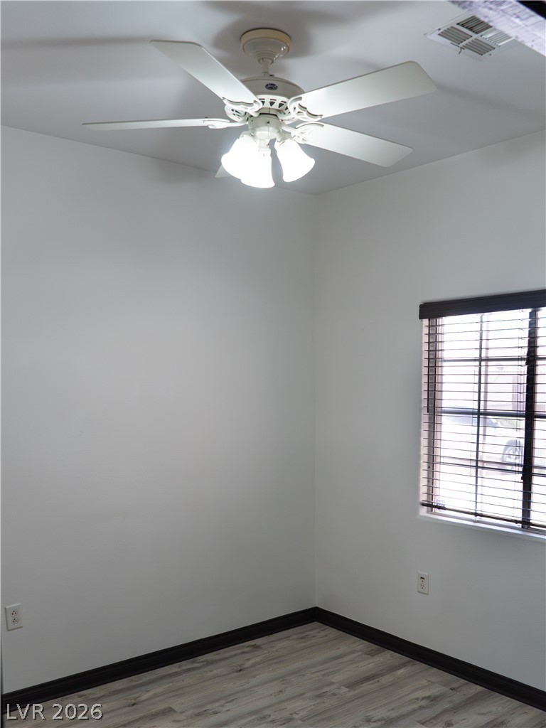 1466 Orange Jubilee Road Henderson, NV 89014 - Photo 6 of 15 Well-lit room featuring durable laminate flooring and a ceiling fan for comfort.