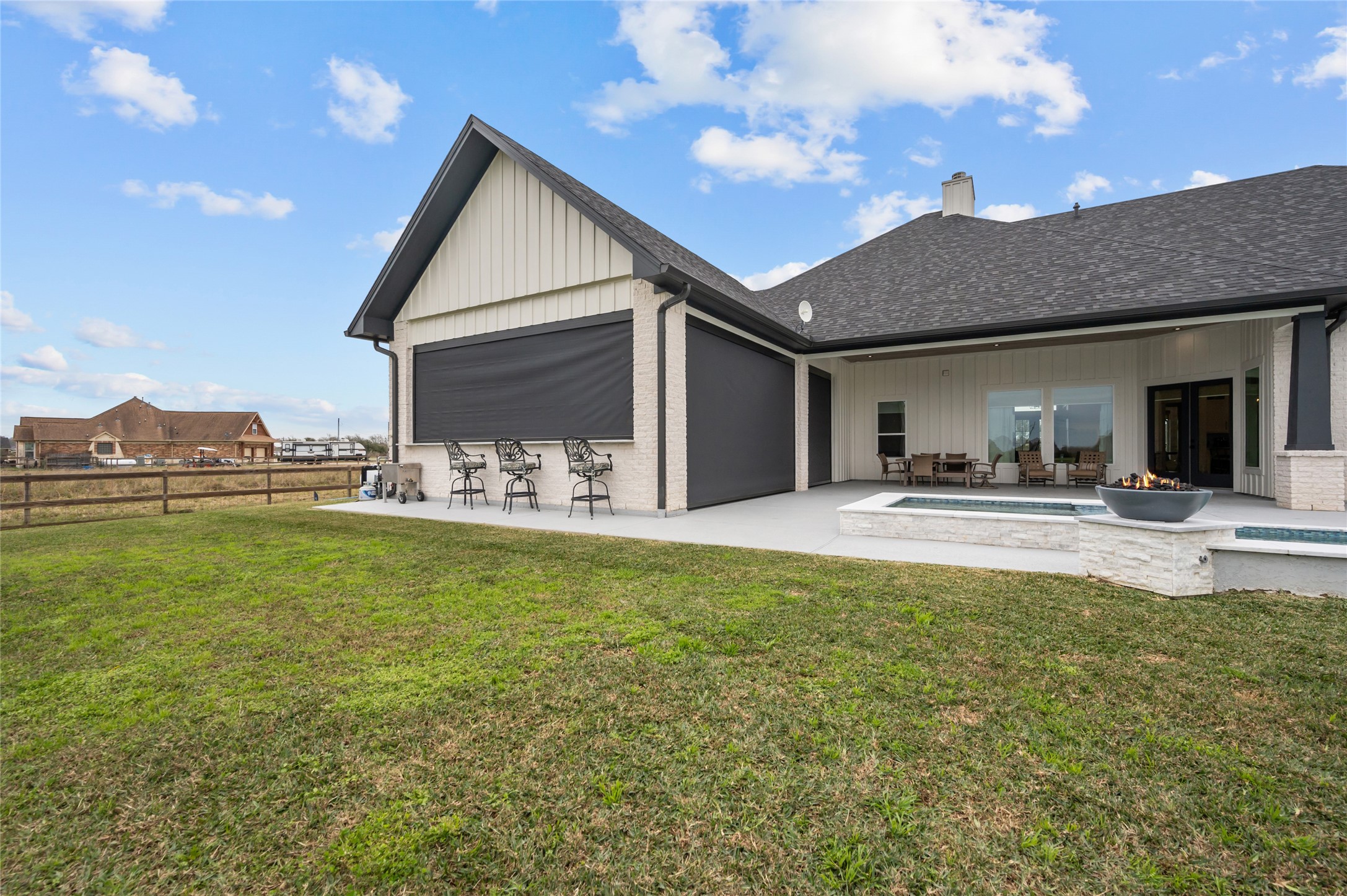 14923 Old Irish Farm Road Baytown, TX 77523 - Photo 40 of 50 Outdoor Kitchen area has motorized cooling shades with AC unit and gas fireplace