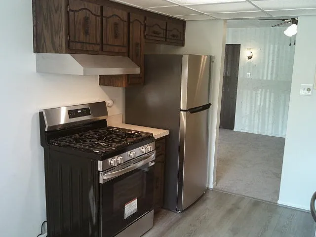 a kitchen with stainless steel appliances granite countertop a refrigerator and a stove