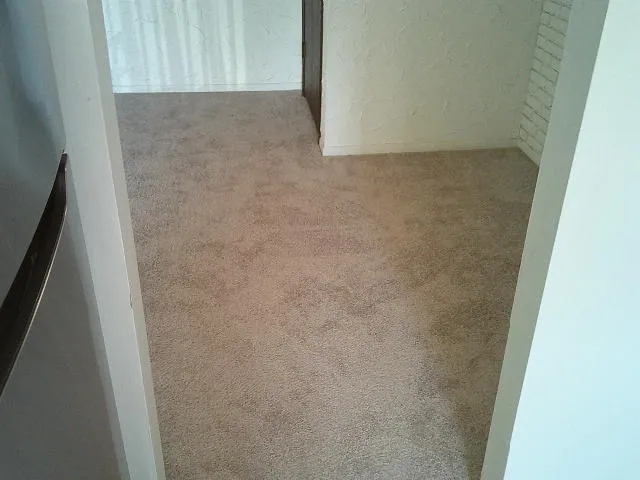 an empty room with closet and mirror