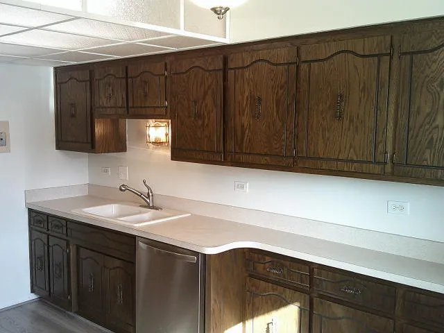a kitchen with a sink cabinets and wooden floor