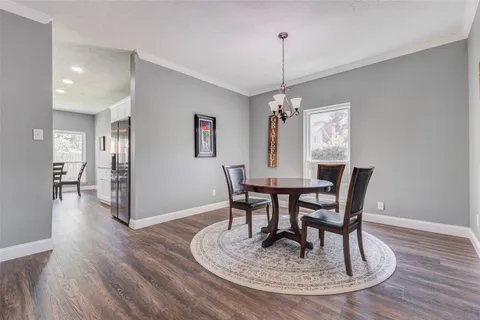 a large kitchen with granite countertop lots of counter space dining table and stainless steel appliances