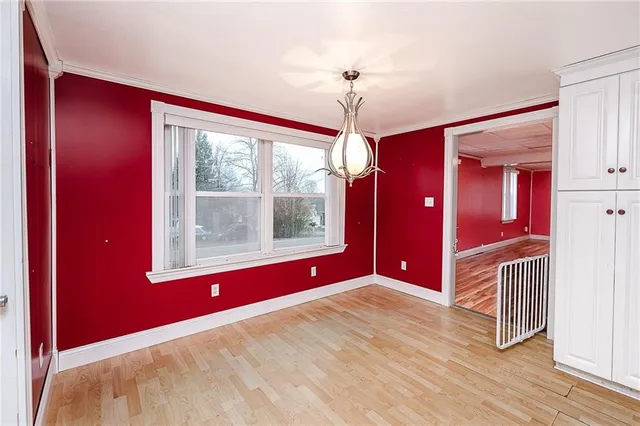 a view of an empty room with a window and a chandelier