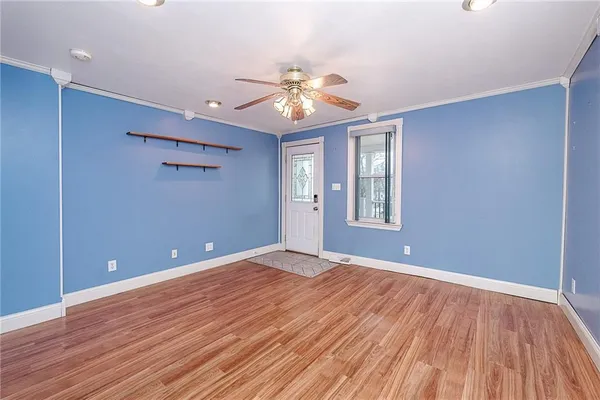 a view of an empty room with window and wooden floor