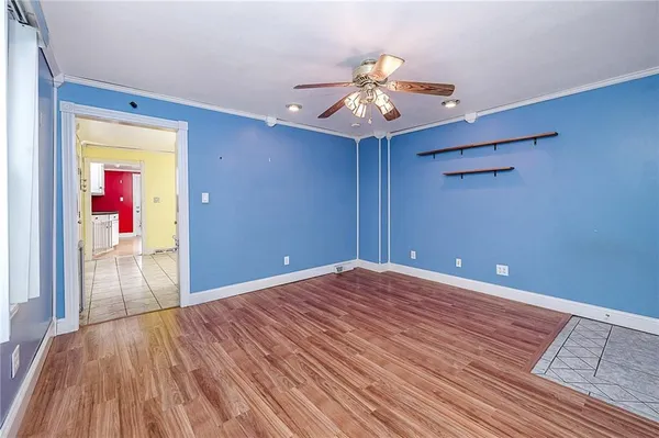a view of a room with wooden floor and ceiling fan