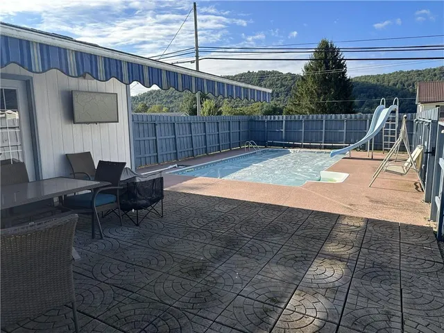 a view of a backyard with furniture and iron fence