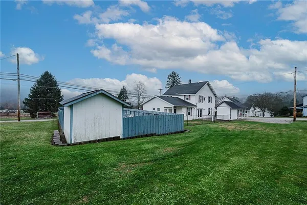 a view of a big house with a big yard and large trees