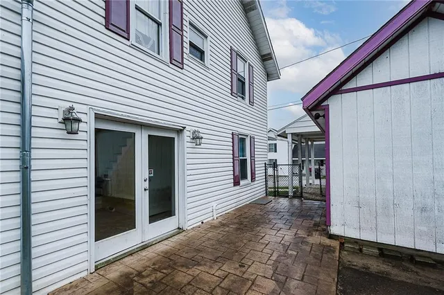 a view of a house with porch and wooden fence