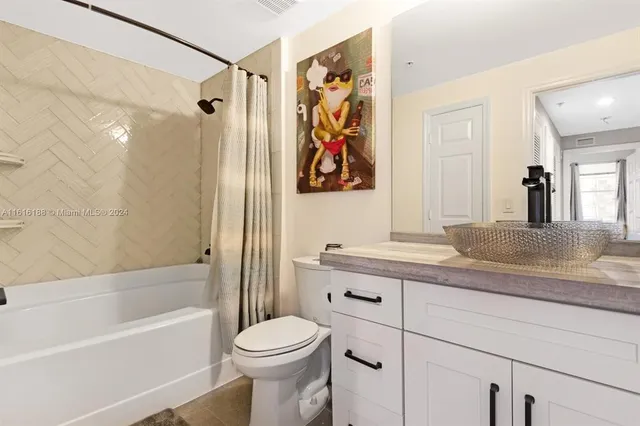 a bathroom with a granite countertop sink a toilet and shower