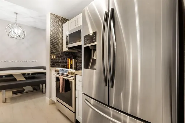 a kitchen with stainless steel appliances granite countertop a refrigerator and a stove