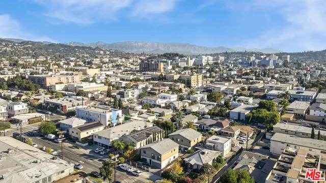 an aerial view of residential houses with outdoor space and trees