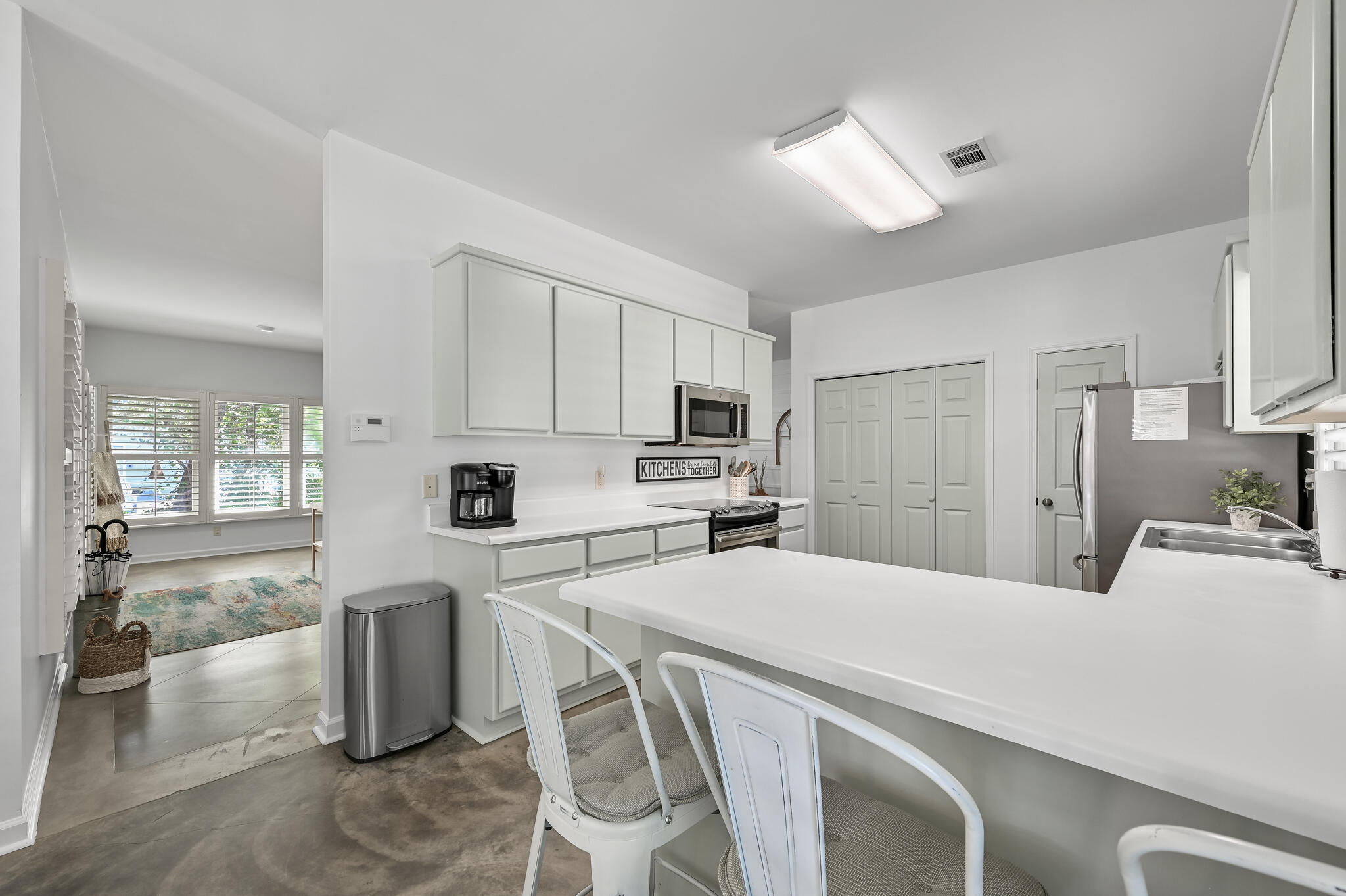 65 Cassine Way Santa Rosa Beach, FL 32459 - Photo 16 of 38 a kitchen with stainless steel appliances a refrigerator a stove a sink dishwasher and white cabinets with wooden floor