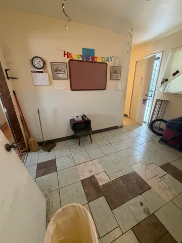 a view of a hallway with wooden floor and a bathroom