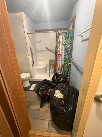 a bathroom with a sink a toilet a mirror and shower