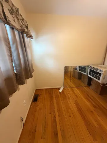 a view of a room with window and hardwood floor