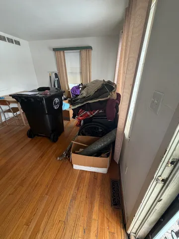 a room with wooden floor and black appliances
