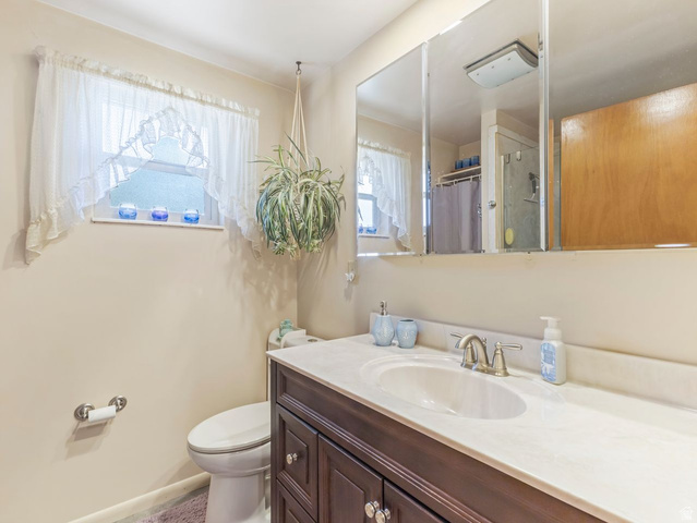 1502 North 475 West Sunset, UT 84015 - Photo 12 of 23 Bathroom with a dark wood-finish vanity, white countertop, and integrated sink