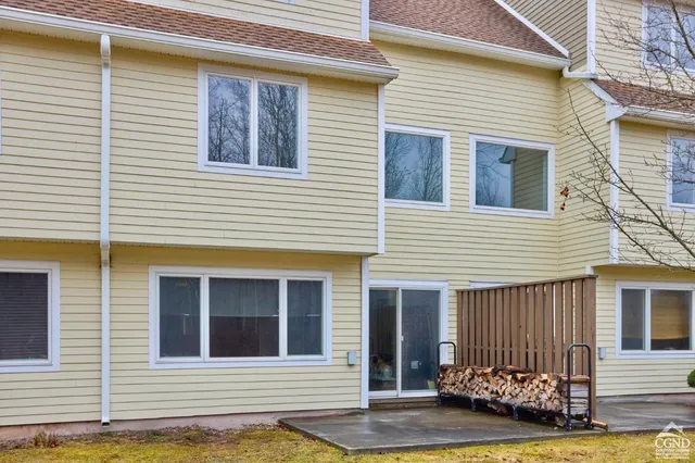a view of a house with small yard plants and wooden fence