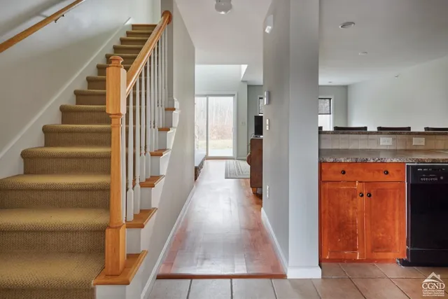 a view of a hallway with wooden floor and staircase