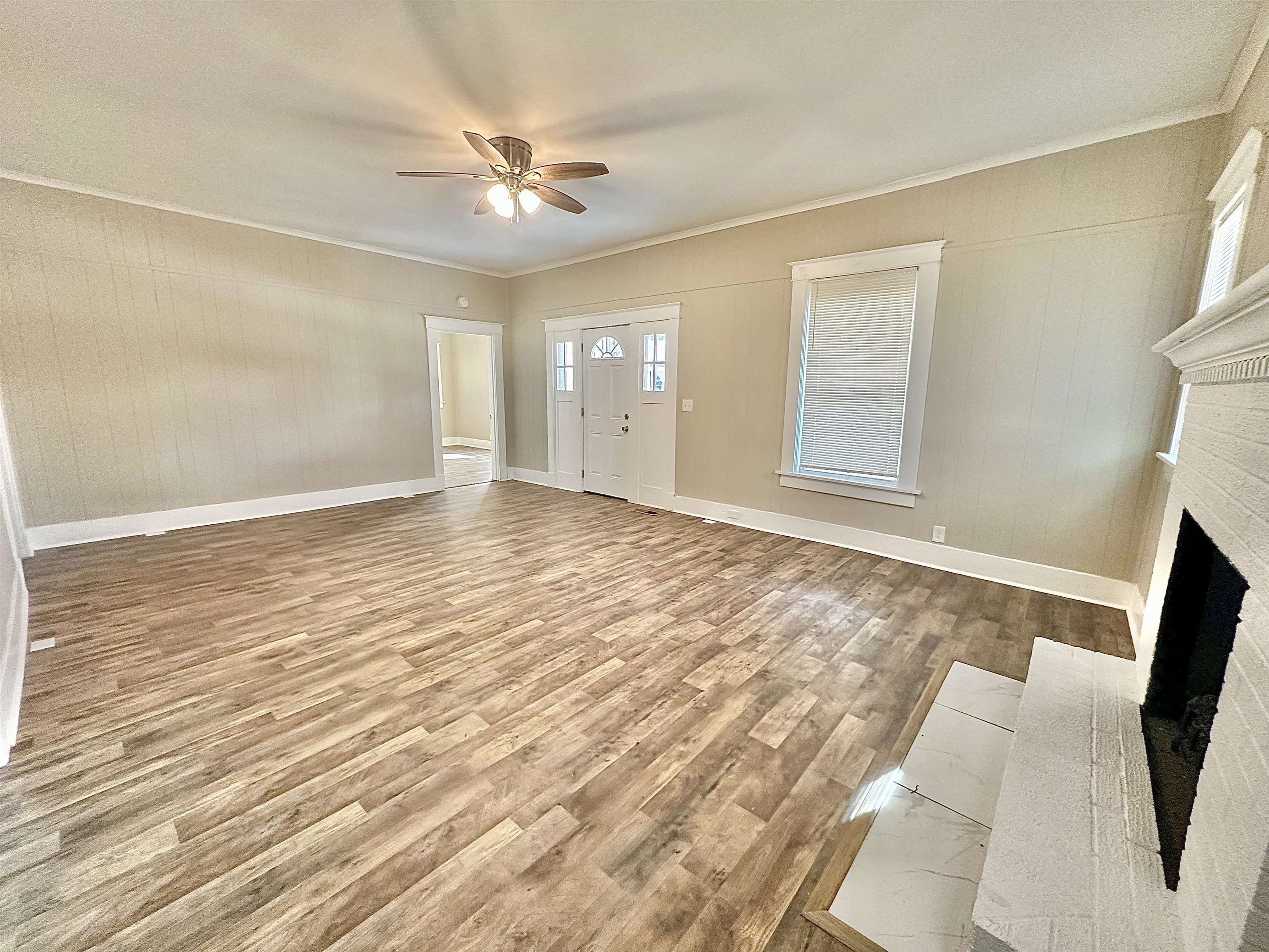 182 South Jefferson Street Ripley, TN 38063 - Photo 4 of 22 an empty room with wooden floor and fan