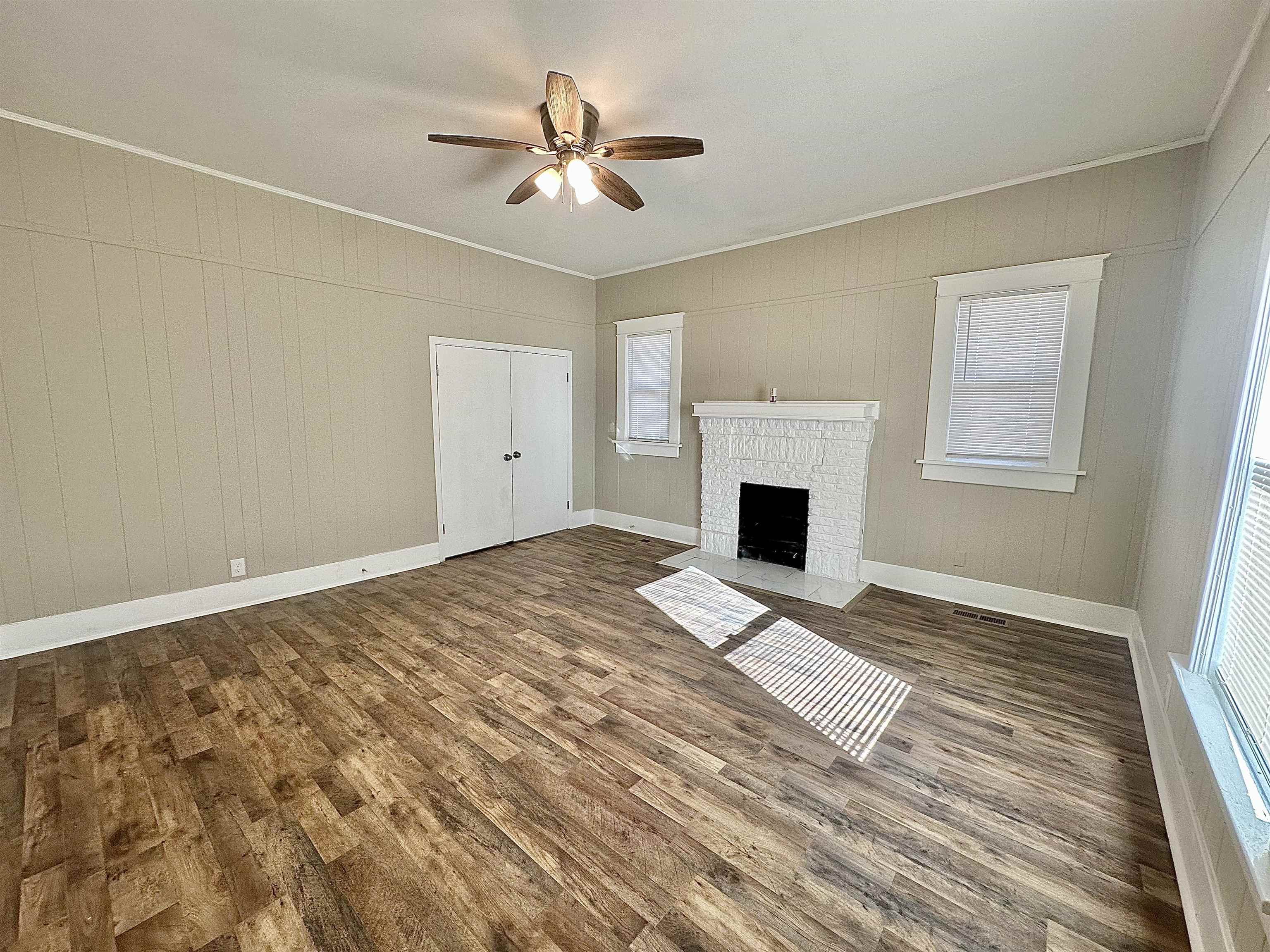 182 South Jefferson Street Ripley, TN 38063 - Photo 10 of 22 a view of a livingroom with a fireplace a ceiling fan and wooden floor