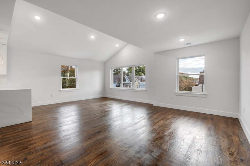 543 13th Avenue Newark, NJ 07103 - Photo 12 of 38 a view of an empty room with wooden floor and a window