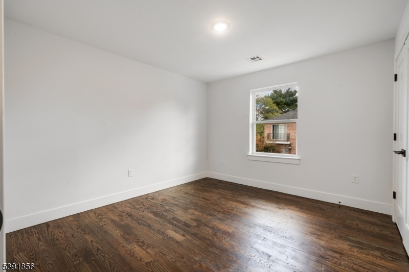 543 13th Avenue Newark, NJ 07103 - Photo 14 of 38 an empty room with wooden floor and windows