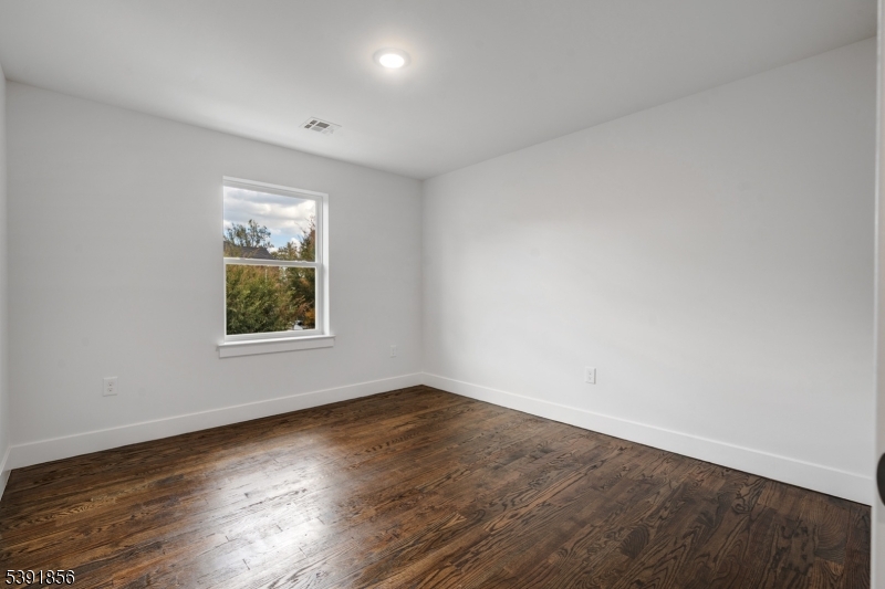 543 13th Avenue Newark, NJ 07103 - Photo 15 of 38 an empty room with wooden floor and windows
