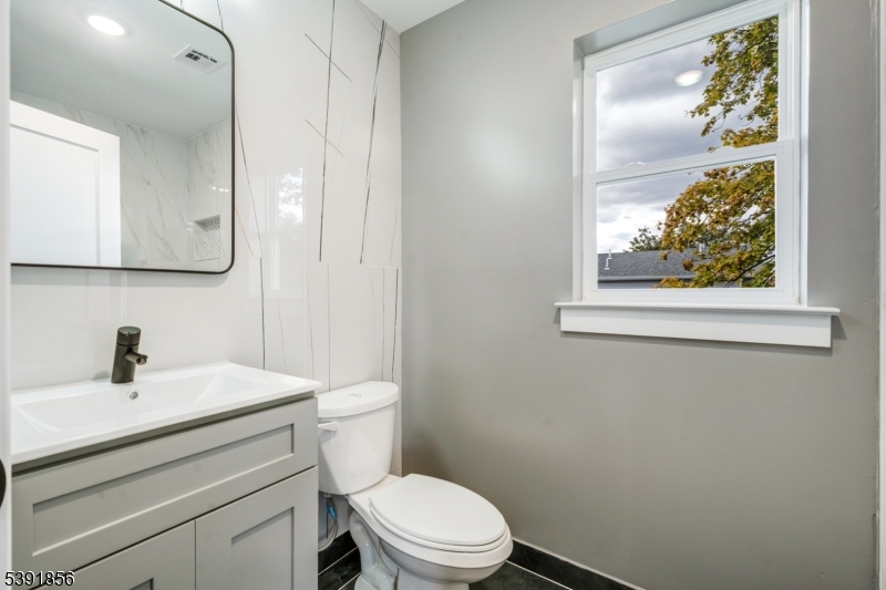 543 13th Avenue Newark, NJ 07103 - Photo 16 of 38 a bathroom with a toilet a sink a vanity and mirror