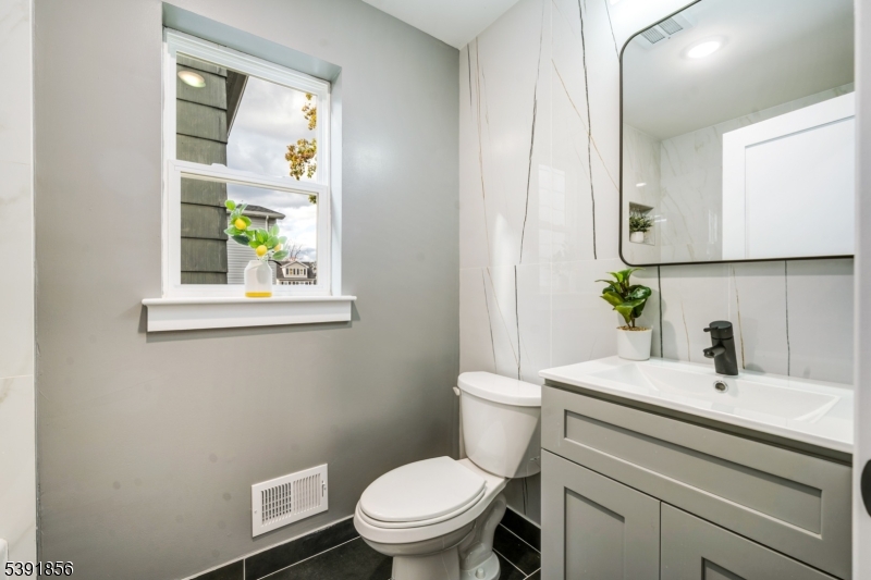 543 13th Avenue Newark, NJ 07103 - Photo 21 of 38 a bathroom with a sink a toilet and a mirror
