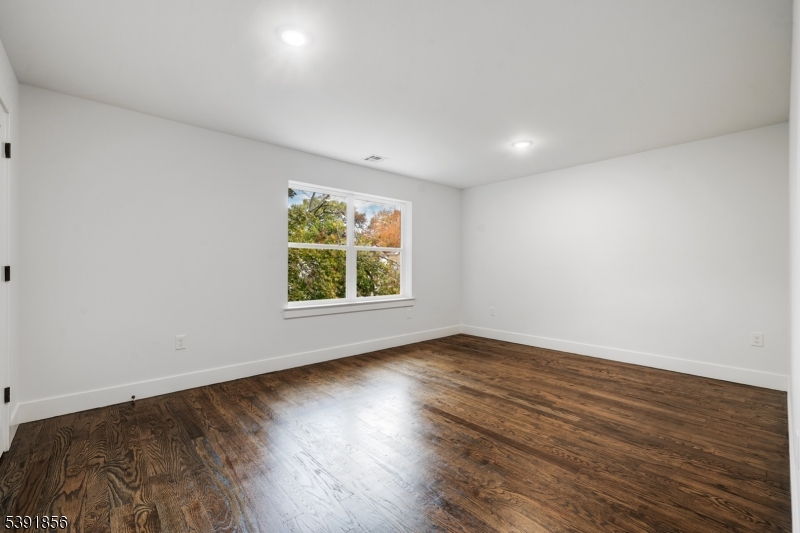 543 13th Avenue Newark, NJ 07103 - Photo 7 of 38 a view of an empty room with wooden floor and a window