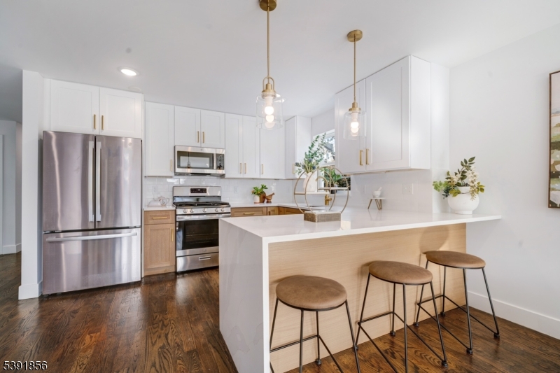 543 13th Avenue Newark, NJ 07103 - Photo 8 of 38 a kitchen with kitchen island white cabinets and stainless steel appliances