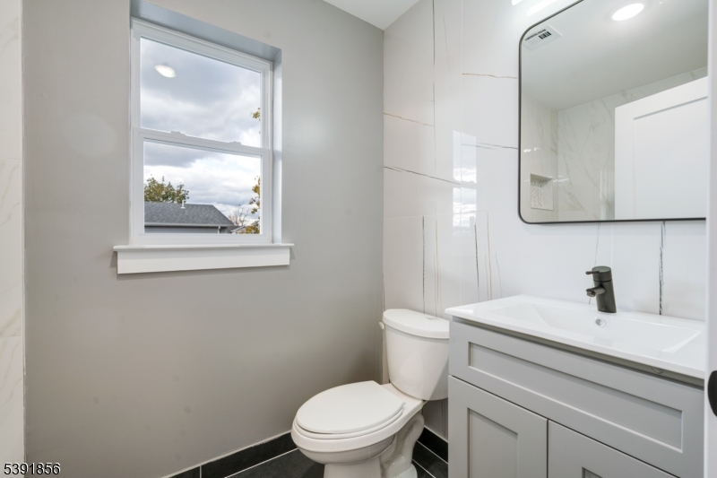 543 13th Avenue Newark, NJ 07103 - Photo 10 of 38 a bathroom with a toilet a sink and mirror